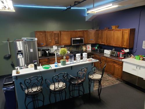 a kitchen with wooden cabinets and a counter with chairs at Artist Housing - Downtown in Los Angeles