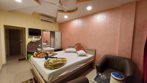 ein Zimmer mit einem Bett und einem Stuhl darin in der Unterkunft Hotel Sea Coast in Digha