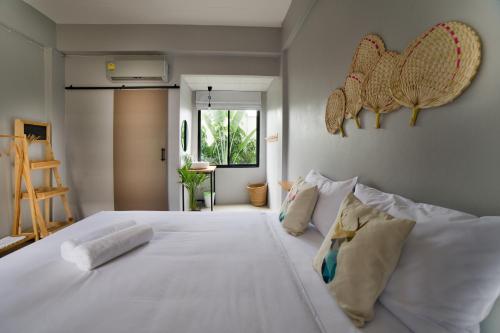 a bedroom with a large white bed with pillows at Home at 9 in Ban Klang (4)