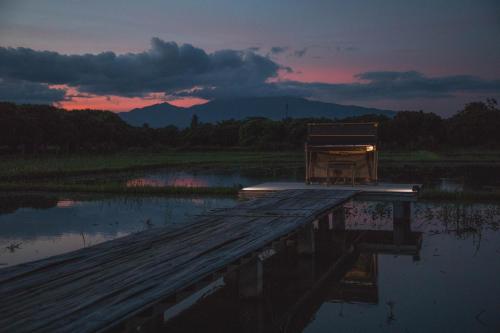 a dock with a chair sitting on top of a body of water at Home at 9 in Ban Klang (4)