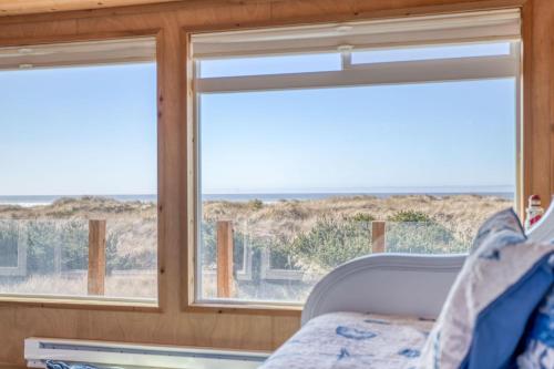a room with two windows and a couch and the ocean at Oceania House in Waldport