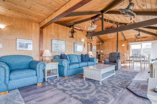 a living room with two blue couches and a table at Oceania House in Waldport