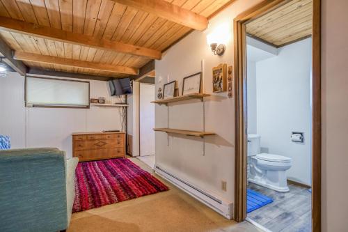 a bathroom with a toilet and a red rug at Oceania House in Waldport