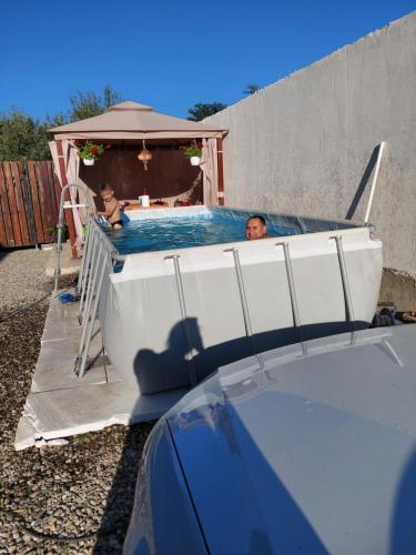 a man and woman in a swimming pool on a boat at Casa Cristina in Cîrţişoara