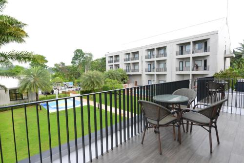 a balcony with chairs and a table and a building at The Chill at Krabi Hotel in Krabi town
