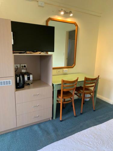 a room with a table with two chairs and a mirror at Temora Motel in Temora