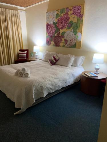 a bedroom with a bed and a painting on the wall at Temora Motel in Temora