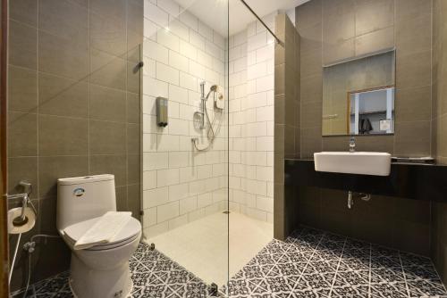 a bathroom with a shower and a toilet and a sink at The Chill at Krabi Hotel in Krabi town