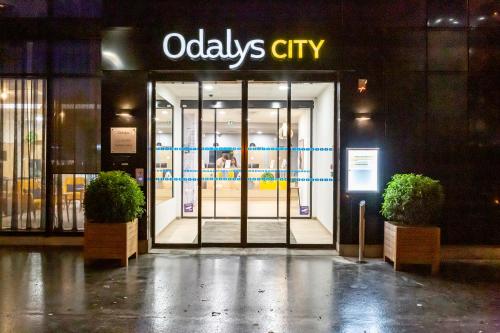 an open door to a oodles city store at night at Appart Hotel Odalys City Le Havre Centre in Le Havre