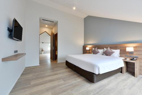 a bedroom with a large bed and a television at The Chill at Krabi Hotel in Krabi town