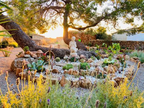 a garden with a statue and some plants at Finca Sa Canova Agroturismo in Campos