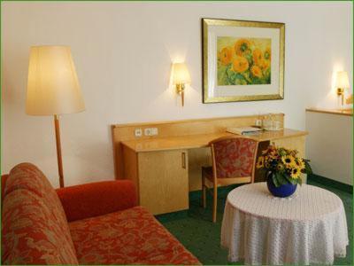 a hotel room with a desk and a chair and a table at Haus am Park in Bad Hersfeld