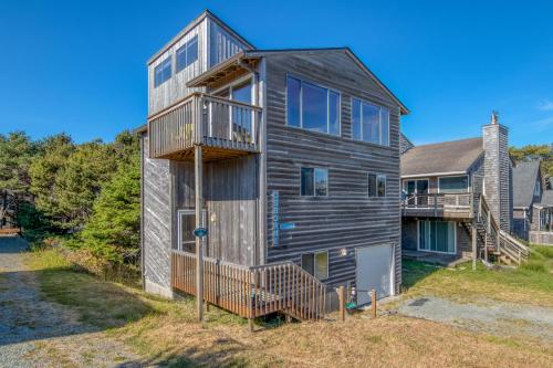 a wooden house with a balcony and a house at Osborne Beach House MCA 139 - Meredith Lodging in Manzanita