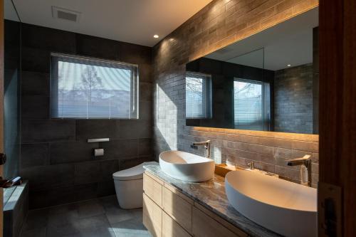 y baño con 2 lavabos, aseo y espejo. en Shion, en Kutchan