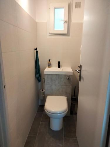 a bathroom with a white toilet and a sink at Edith et Jean-Paul in Porto-Vecchio