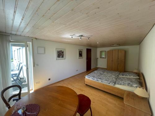 a bedroom with a bed and a wooden table at 2-Zimmer-Nichtraucher-Ferienwohnung Strobel in Tübingen