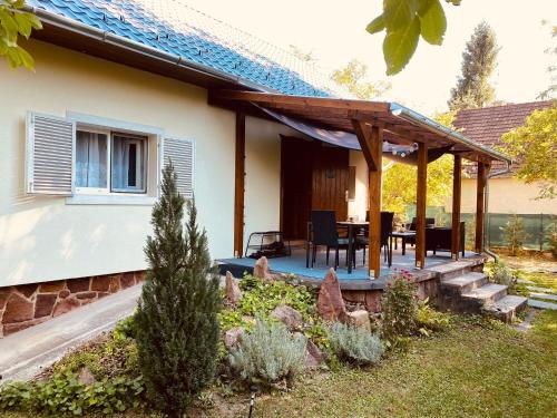 a house with a wooden pergola in a yard at Rév1 Vendégház in Révfülöp