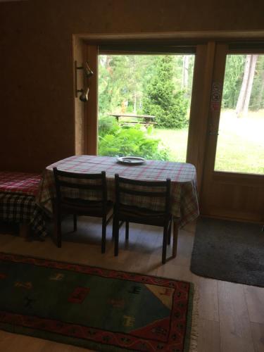 a table and chairs in a room with a window at Voosemetsa Turismitalu in Voose
