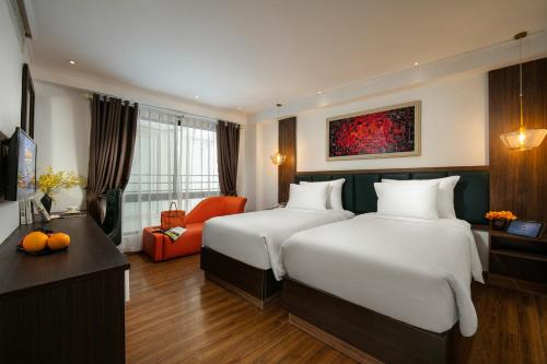 a hotel room with two beds and a desk at Bendecir Hotel & Spa in Hanoi