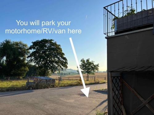 a white pole on a road next to a building at C&C motorhome/RV/caravan/van park in La Sonnaz