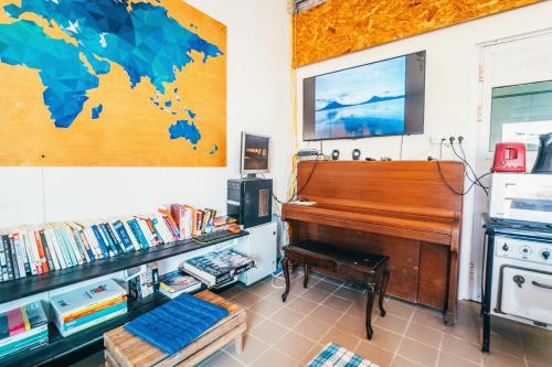 a room with a piano and a book shelf with books at Tsavta in Mashabbe Sade
