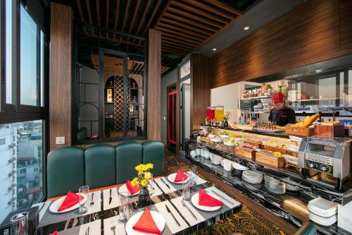 a restaurant with tables and chairs and a counter at Bendecir Hotel & Spa in Hanoi