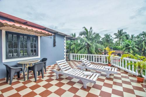 a patio with chairs and a table on a house at Villa Verediana in Candolim