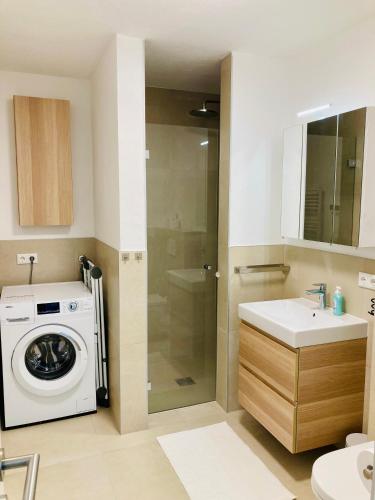a bathroom with a washing machine and a sink at Ferienwohnung Kerschbaumer in Gries am Brenner