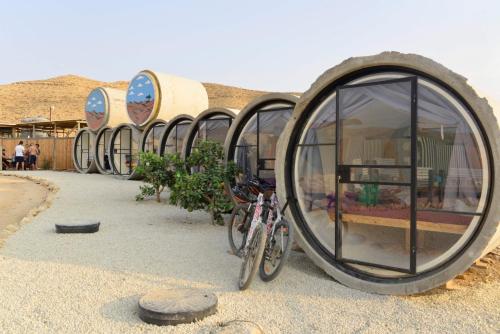a row of circular houses with bikes parked in front at Tsavta in Mashabbe Sade