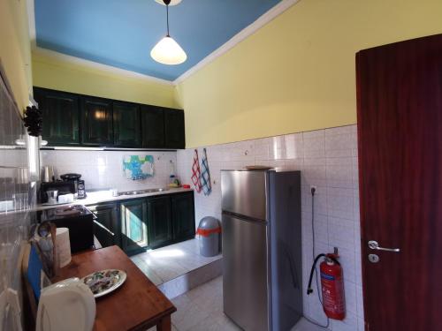 a kitchen with a stainless steel refrigerator and a table at Pelekas Beach Apartments in Pelekas