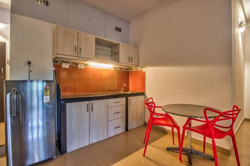 a kitchen with a table and chairs and a refrigerator at Villa Verediana in Candolim
