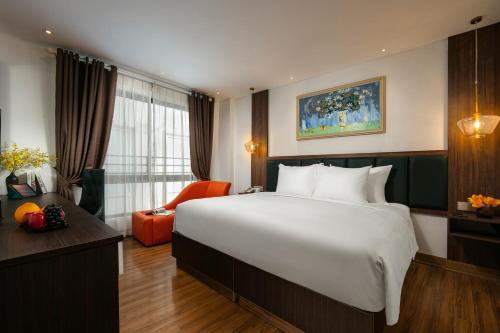 a hotel room with a large bed and a desk at Bendecir Hotel & Spa in Hanoi
