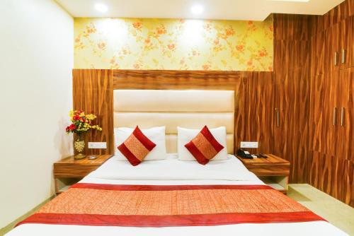 a bedroom with a large white bed with red pillows at Olivia Hotels At Delhi Airport in New Delhi