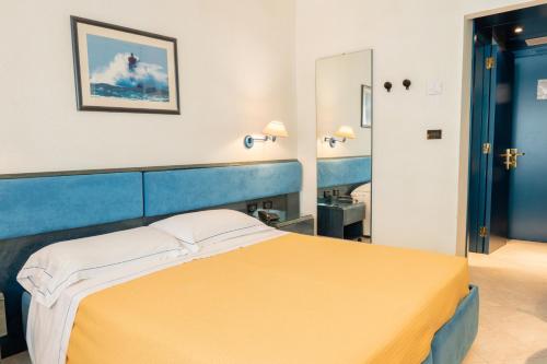 a hotel room with a bed with a yellow blanket at Pizzomunno Vieste Palace Hotel in Vieste