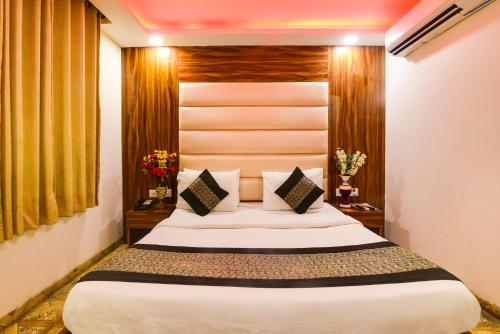 a bedroom with a large bed in a room at Hotel Olivia Inn At Delhi Airport in New Delhi