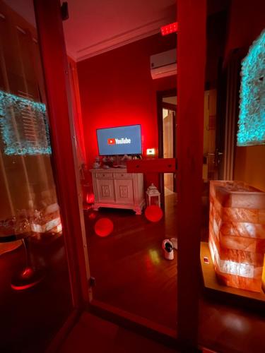 a red room with a television and a desk with a computer at Suite San Rocco Wellness&Spa in Ruvo di Puglia