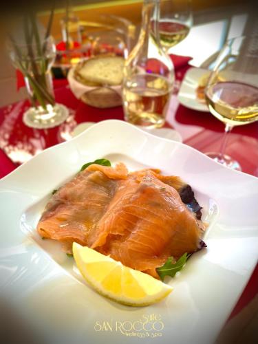 a plate of fish with lemon slices on a table at Suite San Rocco Wellness&Spa in Ruvo di Puglia