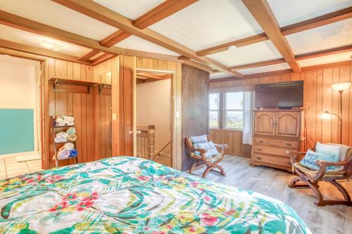 a bedroom with a bed and two chairs and a television at Sea Haven in Lincoln City