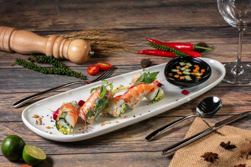 a plate of food with fish and vegetables on a table at Bendecir Hotel & Spa in Hanoi