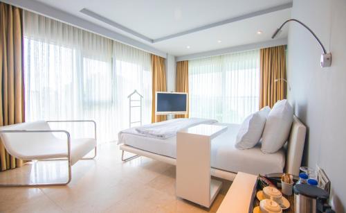 a bedroom with a bed and a chair and a television at Venn Boutique Hotel in Samsun
