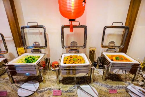 three dishes of food in trays on a table at The King Hotel - Condotel Thai Nguyen in Thái Nguyên