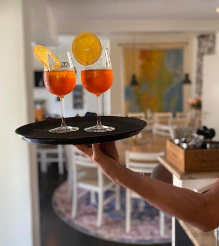 a person holding a tray with three drinks on it at Hedenstugan B&B Hotel in Bergby