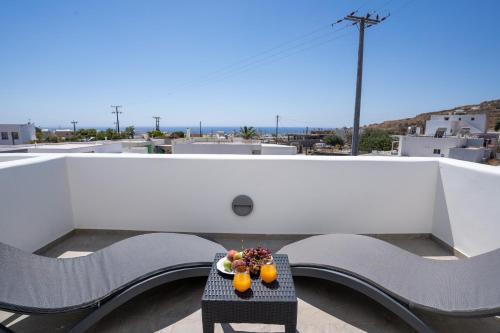 a table with fruit and oranges on a balcony at SantoRossa Luxury Villas in Emporio Santorini