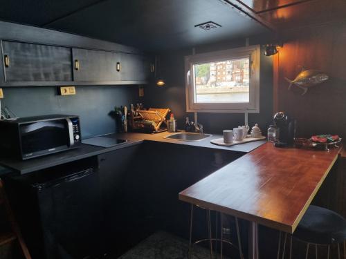 a kitchen with a wooden counter top and a microwave at La Cabine du Capitaine in Liège