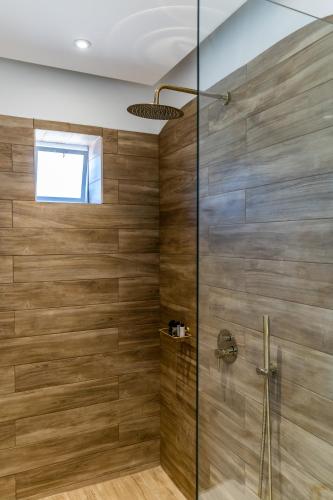 a bathroom with a shower with wooden walls at SantoRossa Luxury Villas in Emporio Santorini