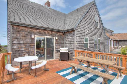 a deck with a bench and a grill on a house at The Nordic House in the Cove - Meredith Lodging in Seaside