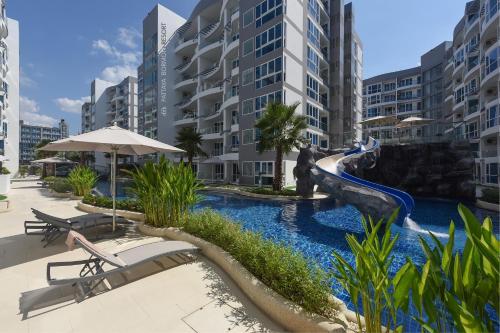 a resort pool with a slide in the middle at Grand Avenue Condo by Bormon in Pattaya Central