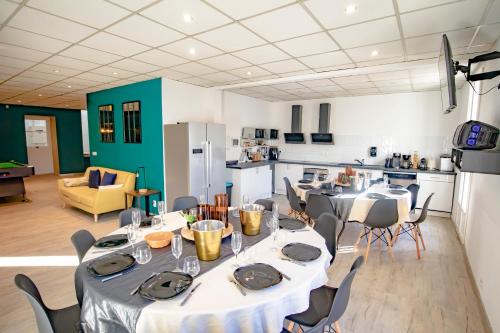 a room with a table and chairs and a kitchen at Le Work&Play - Logement spécial séminaires, vacances, repas. in Clermont-lʼHérault
