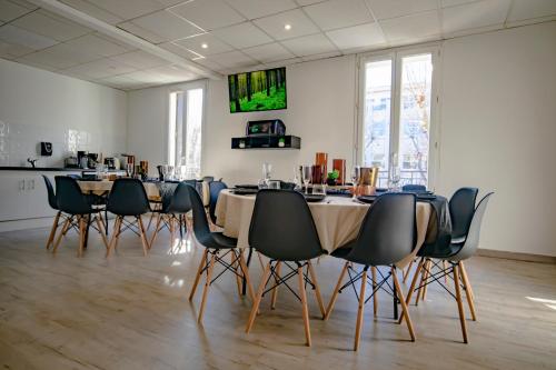 un groupe de tables et de chaises dans une pièce dans l'établissement Le Work&Play - Logement spécial séminaires, vacances, repas., à Clermont-lʼHérault