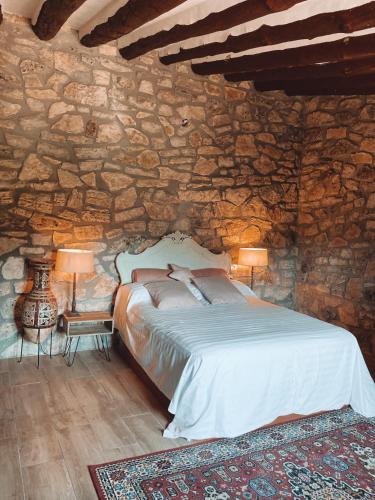 a bedroom with a bed in a stone wall at Masiadenjust in Rojals